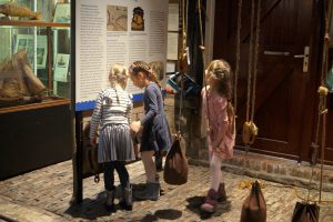 Jonge bezoeksters bekijken een informatiebord in Visserijmuseum Zoutkamp