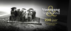 Een zwart-wit foto van een groep mensen met paraplu's in een open landschap.
