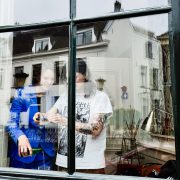 Twee mensen filmen met hun mobiel hoe water in een glas wordt geschonken.