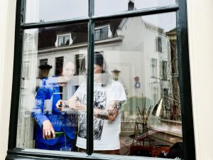 Twee mensen filmen met hun mobiel hoe water in een glas wordt geschonken.
