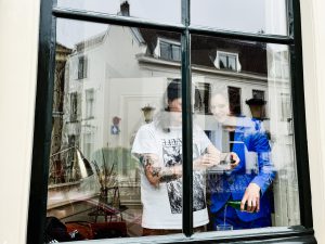 Twee mensen filmen met hun mobiel hoe water in een glas wordt geschonken.