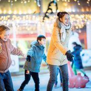 Een vrouw en twee kinderen op de schaatsbaan.