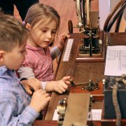 Een meisje en een jongen bekijken en proberen een telegram te bedienen. Fotograaf Turi Kammer