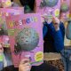 Kinderen houden het tijdschrift Wiesneus voor hun gezicht.